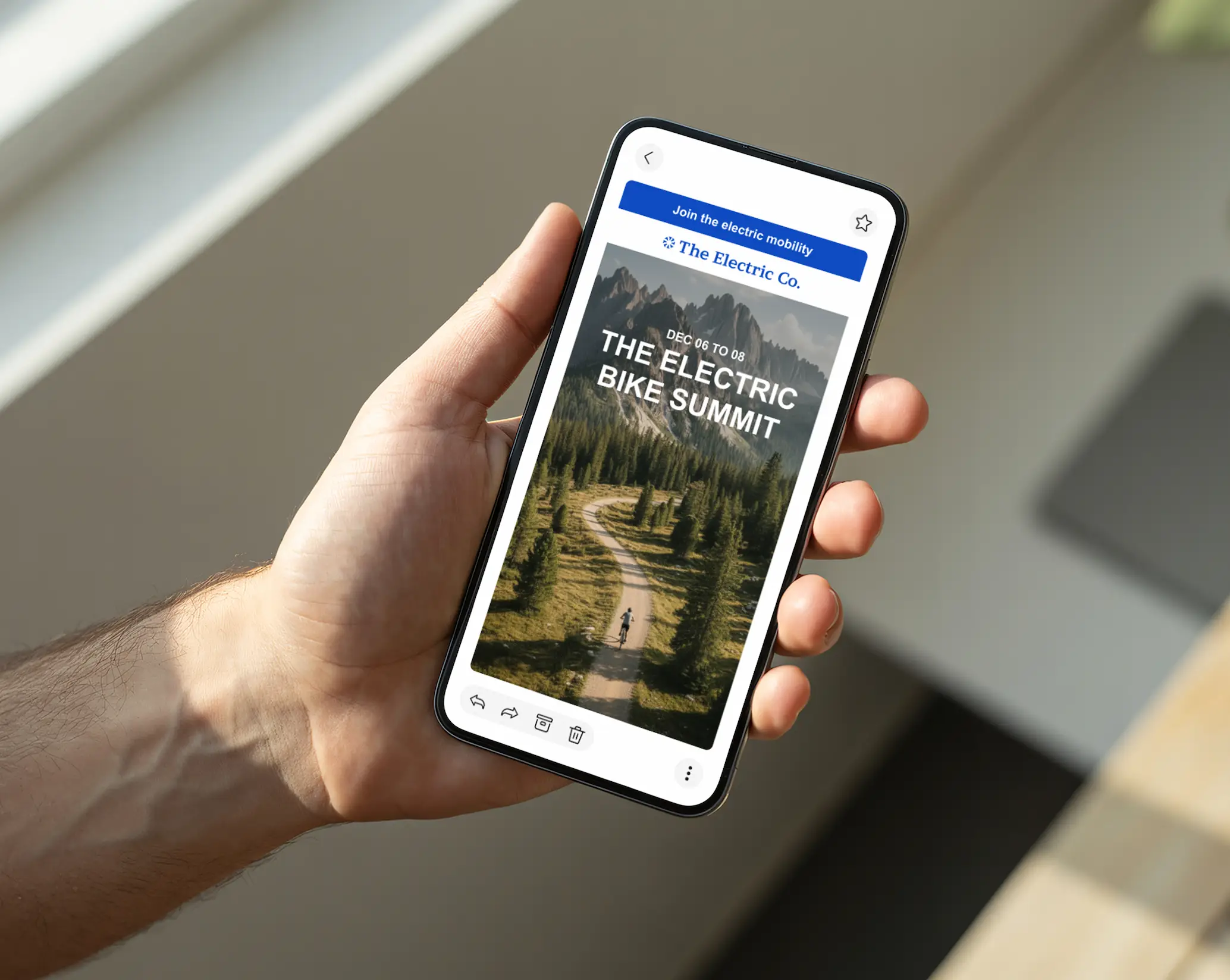 Una mano che tiene un telefono su cui è visualizzata una newsletter